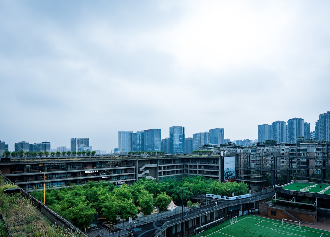 Modern city skyline with green spaces and buildings.
